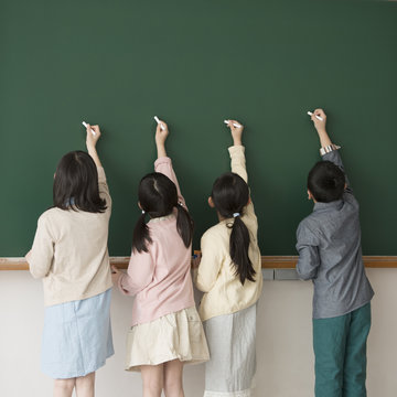 黒板に文字を書く小学生