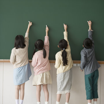 黒板に文字を書く小学生