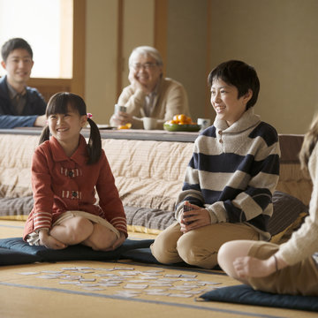 和室でかるた遊びをする親子