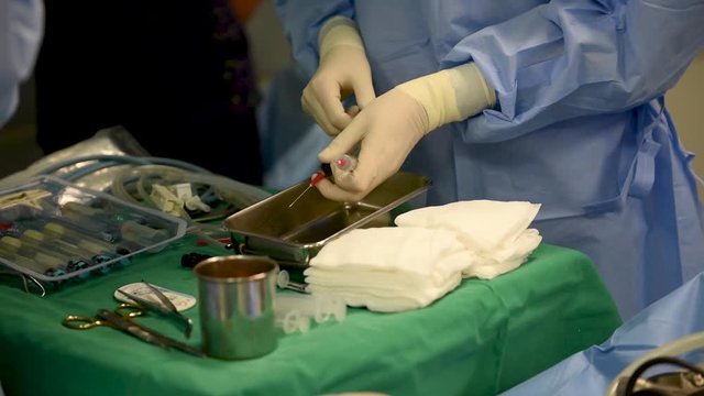 This is medicine related footage from hospital or clinic where professional doctors are operating a surgery or another type of medical healing procedure for injured patient.