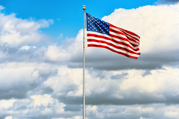 Star-striped American flag flutters proudly against the blue sky.
