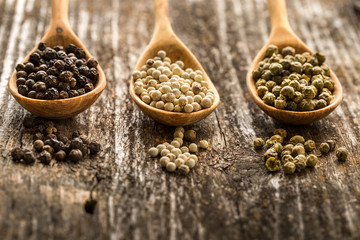 Colored pepper on wooden spoon. herbs and spices