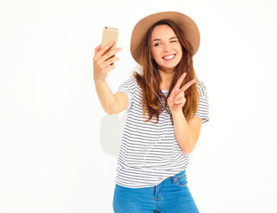 Portrait of a pretty girl in summer hipster clothes taking a selfie isolated on white background....