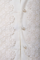 Close up shiny buttons on white women shirt. Fancy decorated shirt, vertical picture.