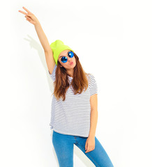 Portrait of young stylish girl model in casual summer clothes in yellow beanie hat isolated on white. Hands in air