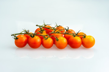 Branch of fresh cherry tomatoes isolated on white background.