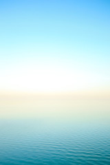 Naklejka na ściany i meble Dawn at the sea. Gentle blue background.