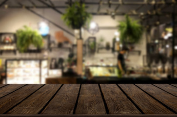 Selected focus empty brown wooden table and Coffee shop or restaurant blur background with bokeh image. for your photomontage or product display
