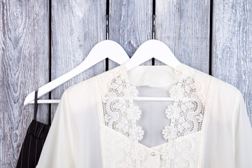 Fashinable woman clothing collection. Close up white lace blouse on hanger.