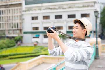 Attractive young man, student or freelance photographer smiles and laughs into camera