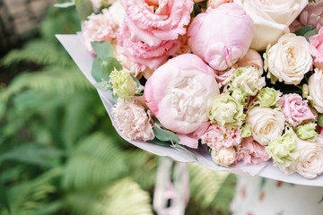 Beautiful summer bouquet. Arrangement with mix flowers. Young girl holding a flower arrangement with peony. The concept of a flower shop. Content for the catalog