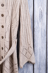 Wool coat sleeve material, close up. Flat lay, top view, wooden desk surface background.