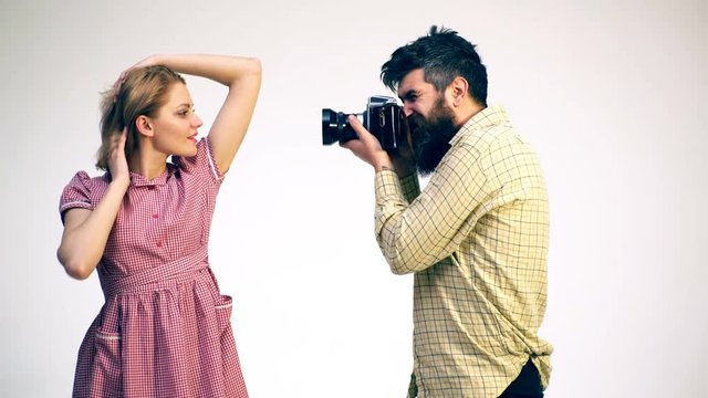 The photographer removes the girl on a film camera. Concept of a photo shoot. A young girl poses in front of the camera.