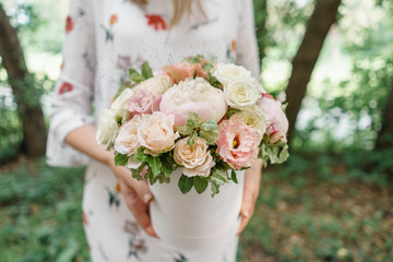 Beautiful summer bouquet. Arrangement with mix flowers. Young girl holding a flower arrangement with peony. The concept of a flower shop. Content for the catalog