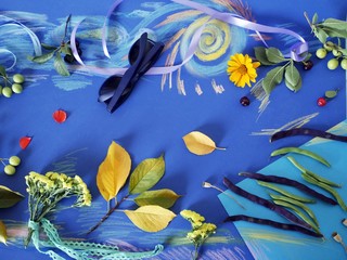  Decorative autumn composition of yellow flowers, leaves, asparagus beans, fruits, colored paper on tinted blue paper, painted with pastel crayons, top view