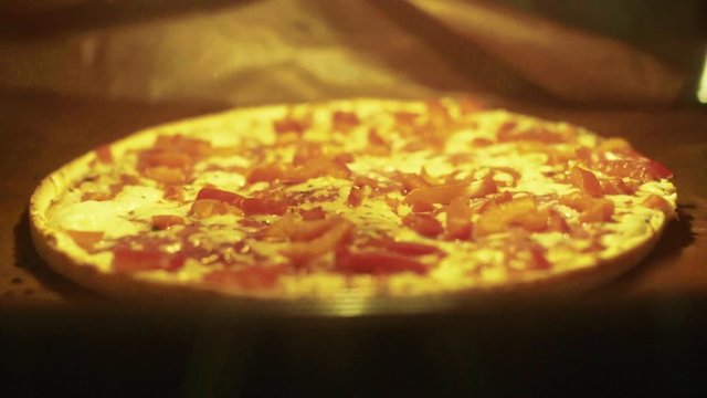 Timelapse of a pizza in the oven getting warm. During this process the pizza extends and gets baked.