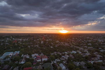 Aerial view of residential houses neighborhood and apartment building complex at sunset.