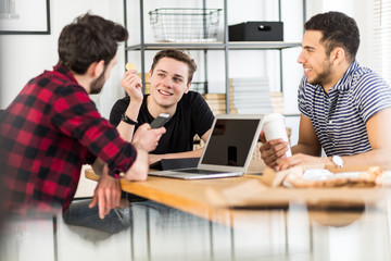 Smiling financier holding gold coin while talking with friends about BitCoin