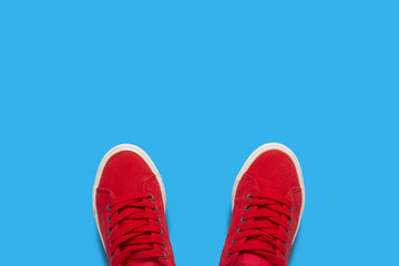 Red sneakers on a blue background. Minimalism style. Flat lay, top view