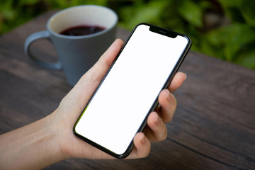 female hands holding phone with isolated screen over the table