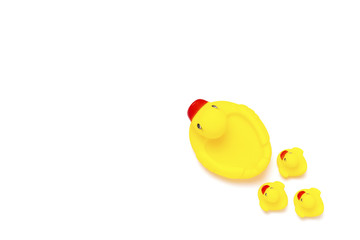 Rubber toy of yellow color Mama duck and small ducklings on a white background. The concept of maternal care and love for children. Flat lay, top view