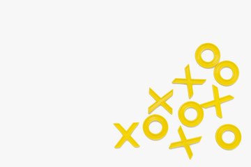 Yellow plastic figures for playing tic-tac-toe on a white background. Flat lay, top view