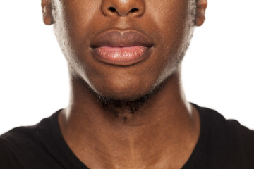 Naklejka premium Zbliżenie usta młodego czarnego faceta african american na białym tle