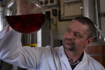 Male worker checking quality of gin