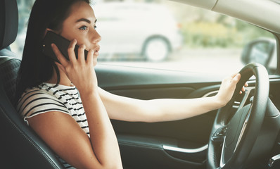 young woman talking on phone in the car.