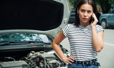 young woman with a broken car