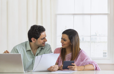 Obraz na płótnie Canvas Couple playing bills using laptop