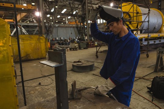 Welder repairing vessel part