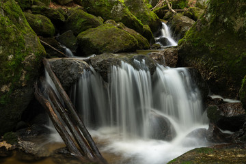 Fototapeta na wymiar Waterfall, cascade between big rocks in ravine Ysperklamm