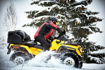 Winter race on an ATV on snow in the forest.