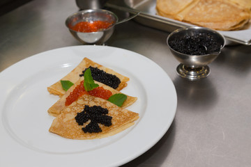 Pancakes with caviar on a white plate. Selective focus. Shallow depth of field