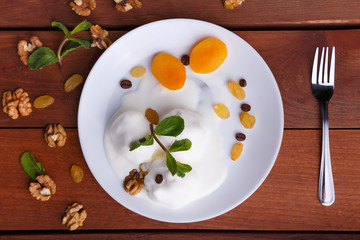 elted ice cream on a plate, decorated with mint and walnuts