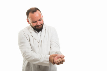 Portrait of male doctor showing wrist pain gesture