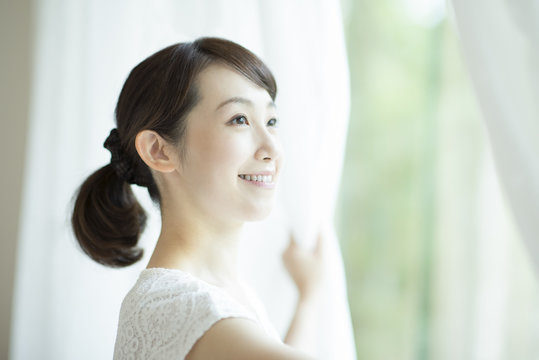 カーテンを開ける女性