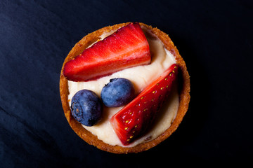 Berry tartlets with blueberries, strawberries and butter cream. Shallow depth of field. Selective focus