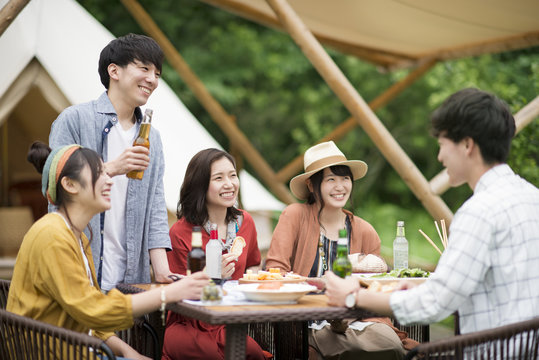 グランピングテントの前で談笑をする若者たち