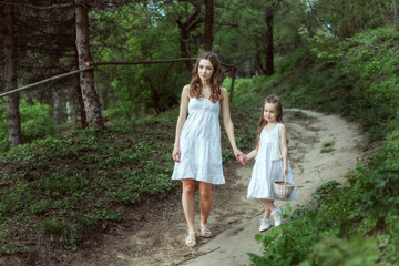 Young mother with her daughter in the woods