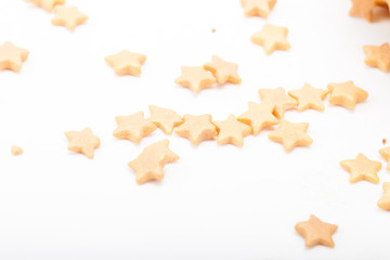 Many gold sugar sters are scattered on a light background © strannik_fox