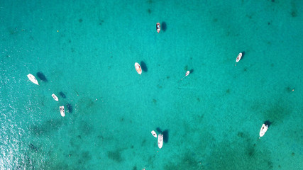 Aerial drone bird's eye view photo of traditional docked fishing boats in chora of island of...