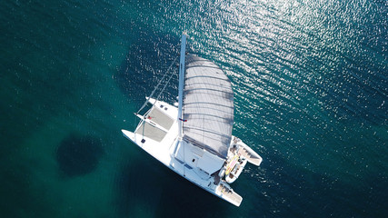 Aerial drone bird's eye view photo from luxury Catamaran docked at tropical deep blue sea - obrazy, fototapety, plakaty