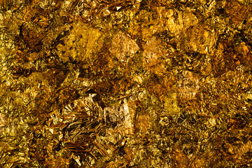 Shiny yellow gold leaf or scraps of gold foil background texture, surface from Back of Buddha image.