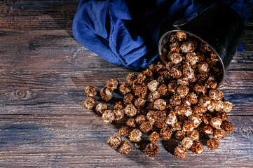 Caramel popcorn on a wooden background. Low key lighting. Selective focus. Close-up. Top view