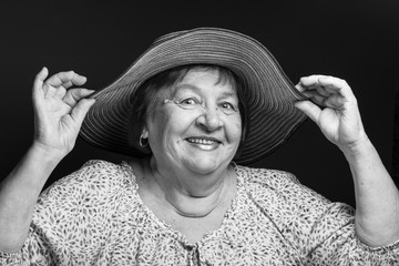 Studio portrait of elderly woman with hat. Smile. Toned