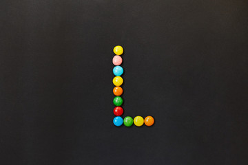 English Alphabet made of colored candies. The letter L.