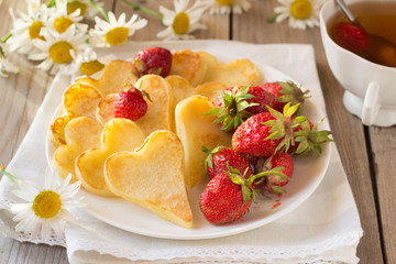 Heart shaped pancakes with strawberry and tea