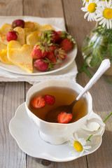 Heart shaped pancakes with strawberry and tea